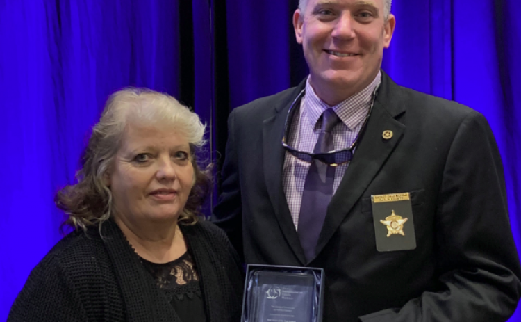 Rabun County Sheriff Chad Nichols, co-chair of the Mountain Judicial Circuit Family Violence Task Force, accepts the task force of the year award from Stephanie Woodard, chair of the Georgia Commission on Family Violence.
