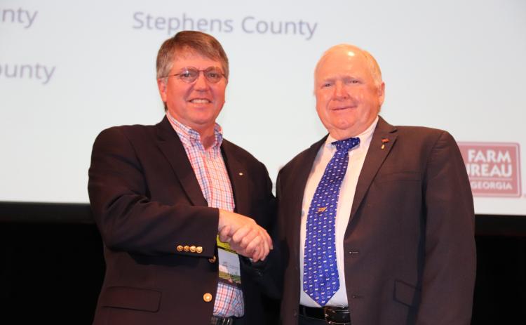Georgia Farm Bureau president Gerald Long (right) congratulates Stephens County Farm Bureau president Mark Wilkinson on the county Farm Bureau’s being named a finalist for the McKemie Award.
