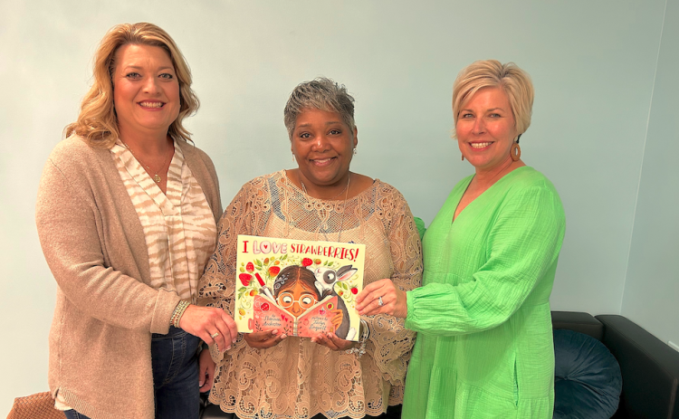 Stephens County Farm Bureau (SCFB) Women’s Committee chair Sonya Stovall (left) and Hart EMC public relations director, Angie Brown (right) recently presented a copy of the children’s ag book I Love Strawberries to Shantelle Grant (center), for the Toccoa-