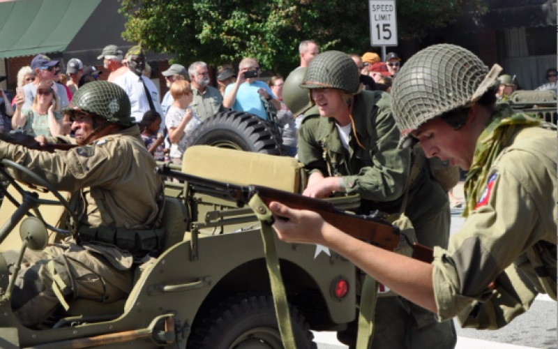 World War II re-enactors fire on a group of German re-enactors holding the Pond Street Bridge during the 2018 military weekend.
