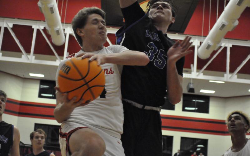 Kenny Colwell collides with Banks County's Carl Cleveland at the hoop. Photo by Marcus Etienne