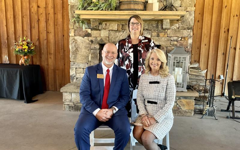 Pam Hill (seated, right) recently received the Pioneer in Education Award. At rear is school superintendent Dr. Connie Franklin.