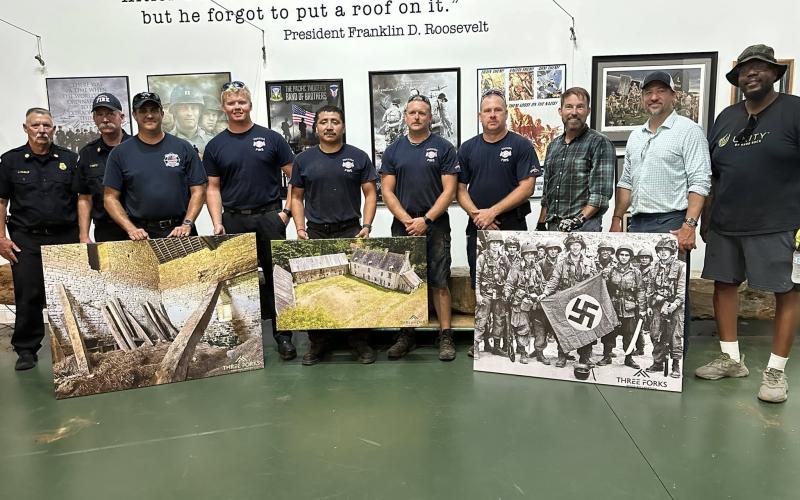 A historic beam from Normandy was given to the Currahee Military Museum on Wednesday, July 9, by Three Forks Wood Reclamation. Pictured are Toccoa Fire Department Chief Jeff Haslup, Assistant Chief Frankie Deitz, Lt. Cale Cobb, firefighter Zac Knell, firefighter Javier Perez-Cristobal, ladder engineer Stacy Lewallen, and Capt. Jonathan Jordan alongside Christian Knutzen and Christopher Kelley of Three Forks Reclamation. Submitted photo
