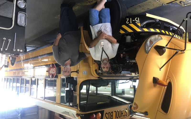 Shop workers at Stephens County High School have been battling the heat to get school buses ready for the start of the school year tomorrow. Pictured are technician Bruce Watts, left, and shop supervisor Brian Pulliam, right. Photo by J. Todd Truelove