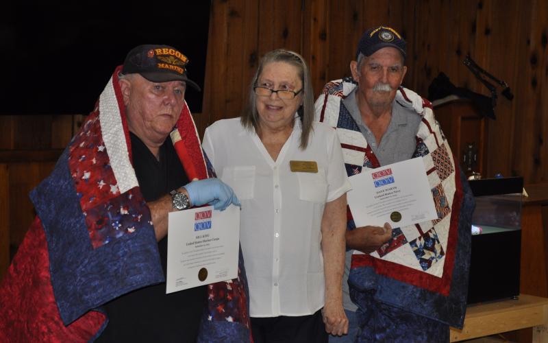 U.S. Marines veteran Bill King, left, and U.S. Navy veteran Dave Warth, right, were honored with Quilts of Valor during Bingo at the VFW headquarters in Toccoa on Monday night as part of a celebration of VFW Post 4346’s 80th anniversary. Karen Trombley, state coordinator for the Quilts of Valor Foundation, presented the quilts. Michael O'Hearn/The Toccoa Record