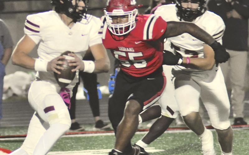 Kymani Colbert (55) puts pressure on the Hebron Christian quarterback in last Friday’s region game.