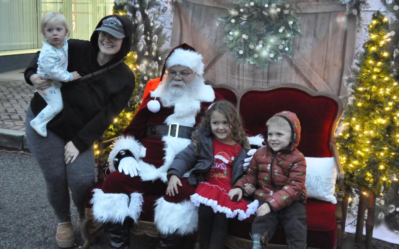 Santa Claus came to downtown Toccoa on Friday night as part of the city’s annual ChristmasFest. He and Mrs. Claus set up a photo opportunity for parents and their children on Doyle Street during the festival. Getting their picture made with Santa Claus are Taylor Sidders, Sagi Sol, Xiius Sol, and Adaeus Sol.