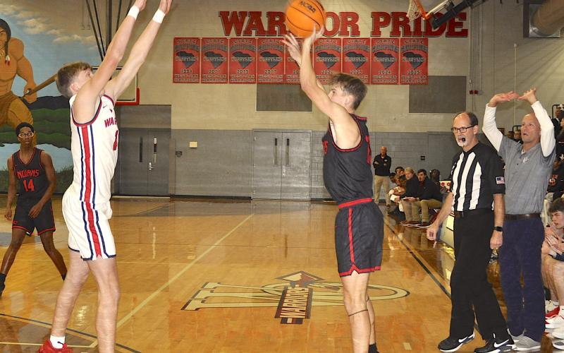 Not even the outstretched arms of a West-Oak defender and the Warrior coach could stop this three-point shot by Stephens County Colson Ivey.