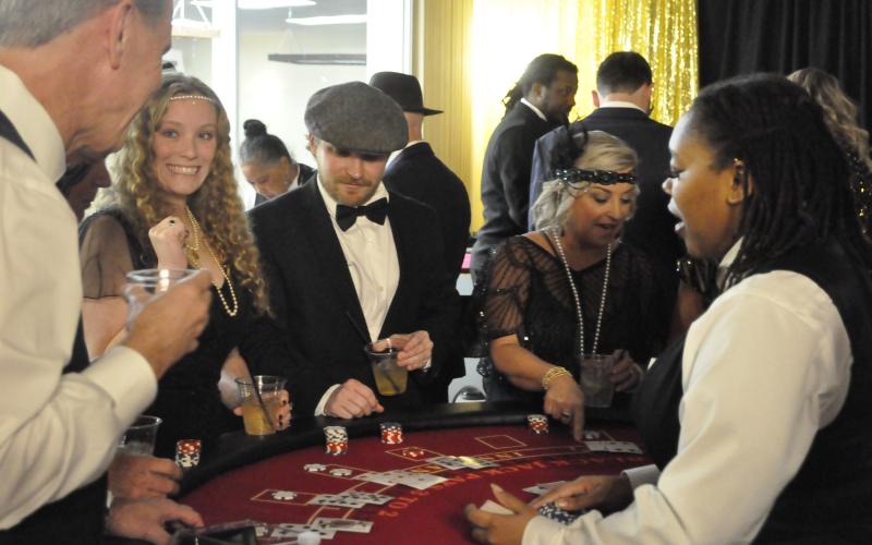 The Toccoa Elks Lodge was transformed into a 1920s-era casino on Saturday night, Feb. 7, for an event to benefit the Open Arms free healthcare clinic. The funds raised can keep the clinic going for three months. Enjoying themselves at a game table are Tim Hawks, Whitney Ledford, Jordan Krippner, and Kimberly Krippner.