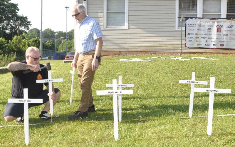 Tom Enlow, left, and Dave Cornelius, right, were busy Wednesday morning placing 36 white crosses on the lawn of the Toccoa American Legion Post 104 home at 610 E. Doyle Street in preparation for Memorial Day on Monday. The crosses represent every war in which the United States has waged since 1776 and the men and women who died in those conflicts. Enlow and Cornelius are both Marine Corps veterans and Post 104 members.