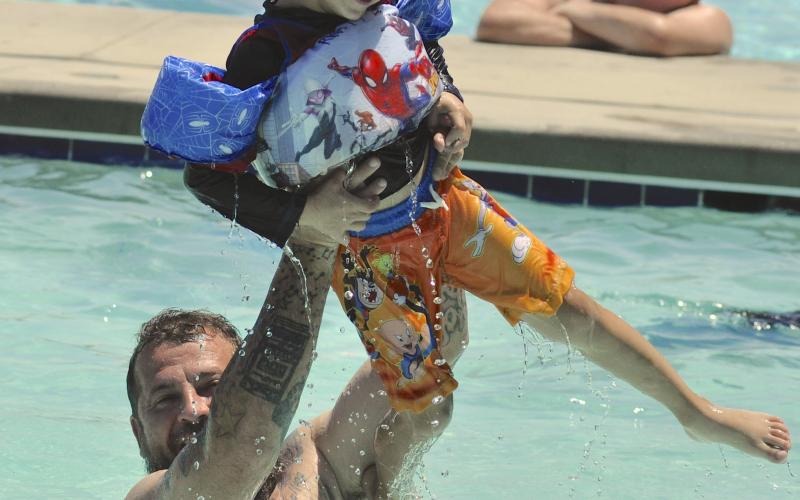 As temperatures climbed into the 90s late last week, city residents went to the pool on Doyle Street to cool down. Among them was Chris Lalumia, seen here tossing his son, Ryatt, into the pool.