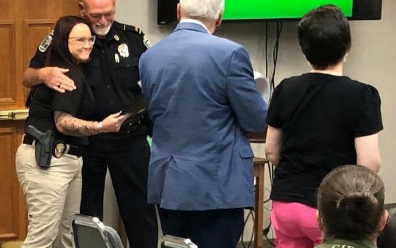 Det. Desiree Thomas, who is being embraced by police chief Bruce Carlisle on the left, was commended Monday, July 13, for her handling of a domestic shooting situation on Friday, July 10.