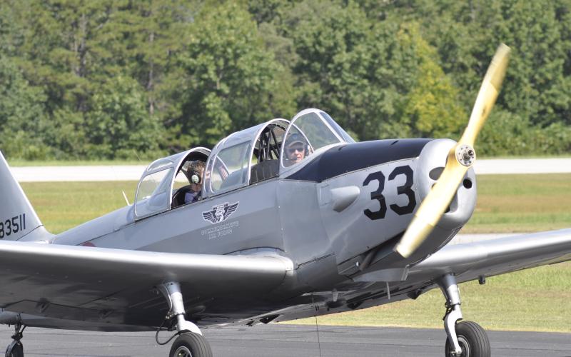 A vintage airplane with pilot George Harrison at the helm lands at the Toccoa-Stephens County Airport.