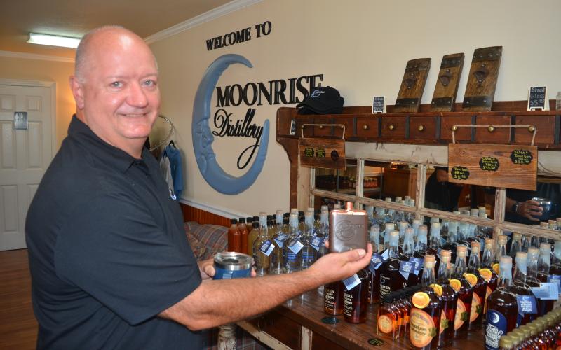 Moonrise DIstillery owner Doug Nassaur shows some of the many bourbon-related products offered for sale at the Clayton distillery.