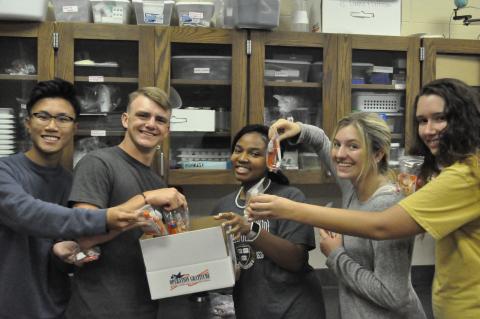 Arvin Dinh, Trevor Burton, Anike Tendell, Ashelyn Merce and J.J. Hayes are making a care package for troops.