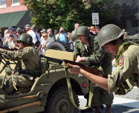  World War II re-enactors fire on a group of German re-enactors holding the Pond Street Bridge during the 2018 military weekend.