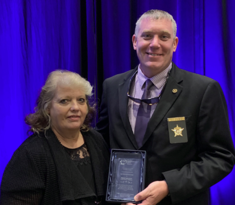 Rabun County Sheriff Chad Nichols, co-chair of the Mountain Judicial Circuit Family Violence Task Force, accepts the task force of the year award from Stephanie Woodard, chair of the Georgia Commission on Family Violence.