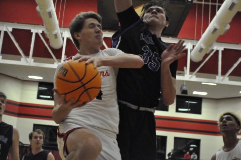 Kenny Colwell collides with Banks County's Carl Cleveland at the hoop. Photo by Marcus Etienne