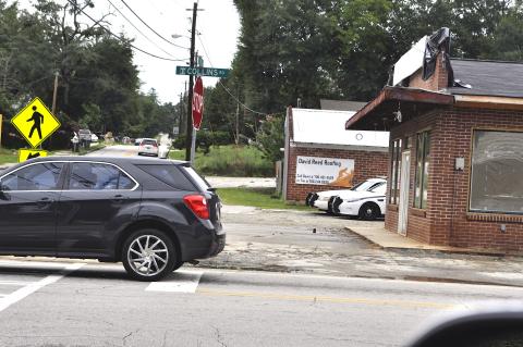 A pair of police cruisers peek out from behind the old Hemphill’s Store building being turned into a Toccoa P.D. substation. Work on the building has been delayed, city manager Billy Morse said.