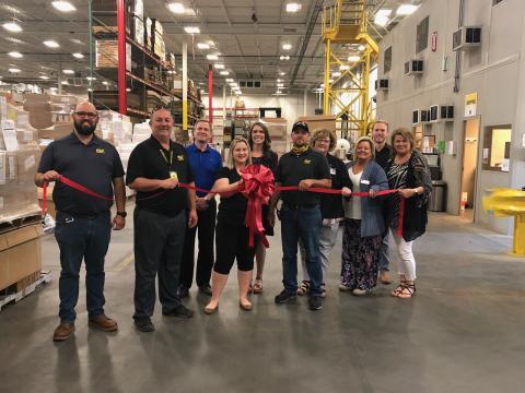 Pictured with Magnaflow staff and chamber of commerce members at last week’s ribbon-tying ceremony are Magnaflow director of distribution Bruce Mellhammer (second from left) and Magnaflow human resources business partner Hailey Beal (behind the ribbon).