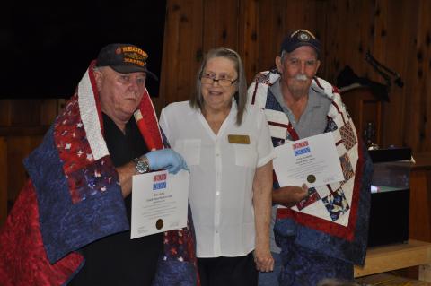 U.S. Marines veteran Bill King, left, and U.S. Navy veteran Dave Warth, right, were honored with Quilts of Valor during Bingo at the VFW headquarters in Toccoa on Monday night as part of a celebration of VFW Post 4346’s 80th anniversary. Karen Trombley, state coordinator for the Quilts of Valor Foundation, presented the quilts. Michael O'Hearn/The Toccoa Record
