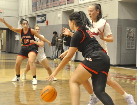 Stephens County’s Aleah Curry (30) drives to the basket as teammate Ivey Jackson (32) manuevers for the ball.