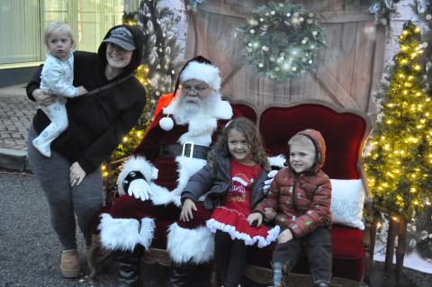 Santa Claus came to downtown Toccoa on Friday night as part of the city’s annual ChristmasFest. He and Mrs. Claus set up a photo opportunity for parents and their children on Doyle Street during the festival. Getting their picture made with Santa Claus are Taylor Sidders, Sagi Sol, Xiius Sol, and Adaeus Sol.