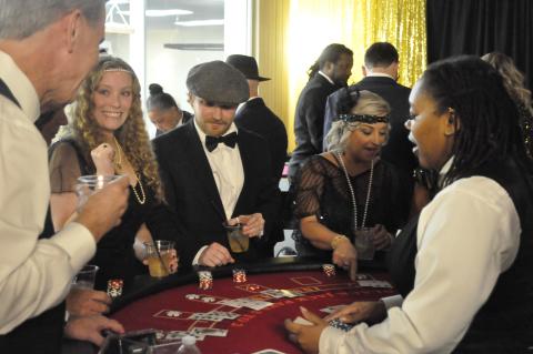 The Toccoa Elks Lodge was transformed into a 1920s-era casino on Saturday night, Feb. 7, for an event to benefit the Open Arms free healthcare clinic. The funds raised can keep the clinic going for three months. Enjoying themselves at a game table are Tim Hawks, Whitney Ledford, Jordan Krippner, and Kimberly Krippner.