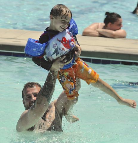 As temperatures climbed into the 90s late last week, city residents went to the pool on Doyle Street to cool down. Among them was Chris Lalumia, seen here tossing his son, Ryatt, into the pool.