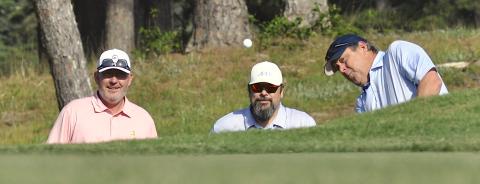 Teammates Benji Harrison and Josh Horton watch closely as Jamie Roberts chips to the ninth green.