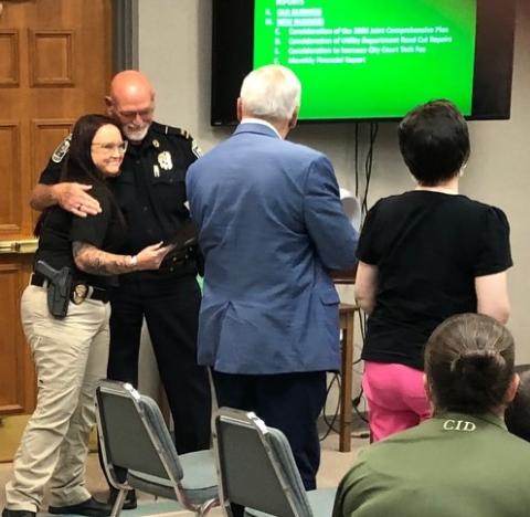 Det. Desiree Thomas, who is being embraced by police chief Bruce Carlisle on the left, was commended Monday, July 13, for her handling of a domestic shooting situation on Friday, July 10.