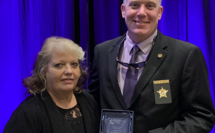 Rabun County Sheriff Chad Nichols, co-chair of the Mountain Judicial Circuit Family Violence Task Force, accepts the task force of the year award from Stephanie Woodard, chair of the Georgia Commission on Family Violence.