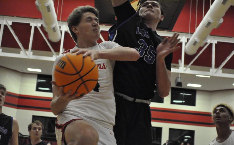 Kenny Colwell collides with Banks County's Carl Cleveland at the hoop. Photo by Marcus Etienne