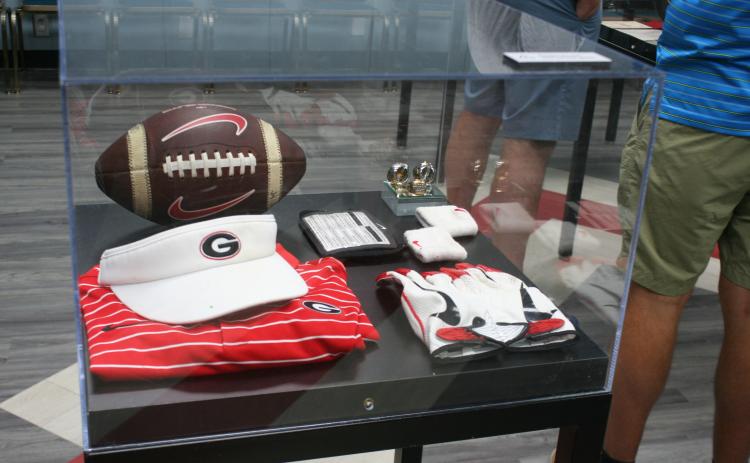 The “UGA Athletics in Your Town” display tour made a stop at the Toccoa-Stephens County Library on Friday, Aug. 1. Some of the items included in the exhibit were UGA 2’s collar, license plates, and an antique football helmet. Laura Shaw/The Toccoa Record