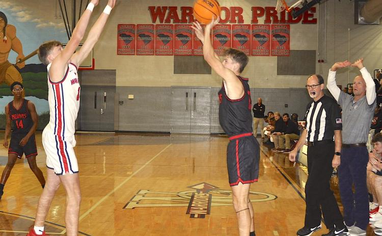 Not even the outstretched arms of a West-Oak defender and the Warrior coach could stop this three-point shot by Stephens County Colson Ivey.