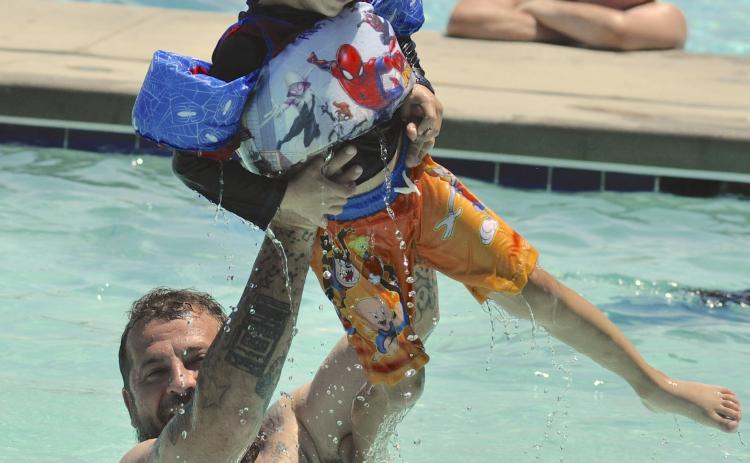 As temperatures climbed into the 90s late last week, city residents went to the pool on Doyle Street to cool down. Among them was Chris Lalumia, seen here tossing his son, Ryatt, into the pool.