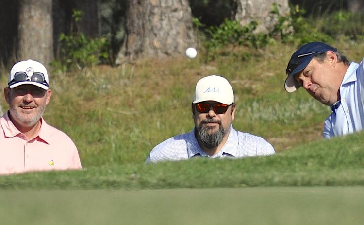 Teammates Benji Harrison and Josh Horton watch closely as Jamie Roberts chips to the ninth green.