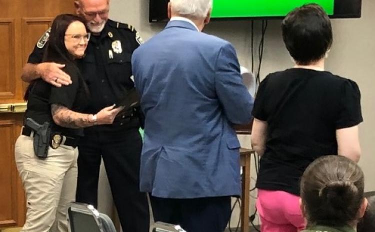 Det. Desiree Thomas, who is being embraced by police chief Bruce Carlisle on the left, was commended Monday, July 13, for her handling of a domestic shooting situation on Friday, July 10.