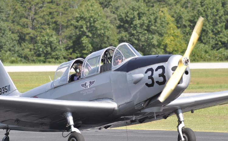 A vintage airplane with pilot George Harrison at the helm lands at the Toccoa-Stephens County Airport.
