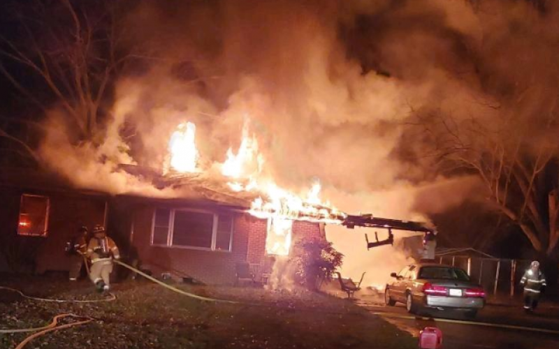 Flames erupt from a house on Old Brookhaven Circle early Monday.
