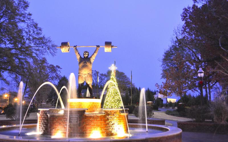 The Paul Anderson Memorial Park decorated for Christmas including the fountain in the foreground and Christmas tree in the background.
