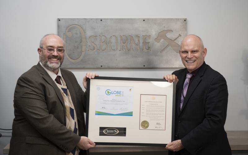 Osborne Wood marketing director Jeremy McClain (left) and company CEO Leon Osborne (right) display the Globe Award.