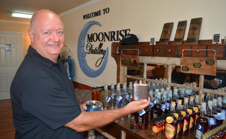 Moonrise DIstillery owner Doug Nassaur shows some of the many bourbon-related products offered for sale at the Clayton distillery.